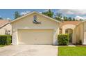 Well-maintained home features a two-car garage and a neatly landscaped front yard, under a bright sky at 21209 Diamonte Dr, Land O Lakes, FL 34637