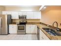Modern kitchen features stainless steel appliances, granite countertops, and ample white cabinetry at 21209 Diamonte Dr, Land O Lakes, FL 34637