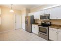 Well-lit kitchen offers modern stainless steel appliances, white cabinets, and tiled flooring at 21209 Diamonte Dr, Land O Lakes, FL 34637