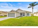 Beautiful single-story home featuring a manicured lawn, screened entryway, and attached two-car garage at 2227 North Creek Ct, Sun City Center, FL 33573