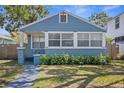 Blue bungalow with white trim, showcasing a quaint front yard and garden at 2720 14Th N Ave, St Petersburg, FL 33713