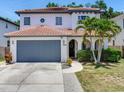 Two-story home with a clay tile roof, arched entryway, and mature landscaping at 3003 W Leila Ave, Tampa, FL 33611