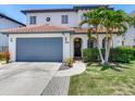Two-story home with a clay tile roof, arched entryway, and lush landscaping at 3003 W Leila Ave, Tampa, FL 33611