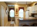 Bright kitchen featuring white cabinets, tile floors, and a breakfast bar, perfect for casual dining at 311 Kelsey Way # 3, Sun City Center, FL 33573