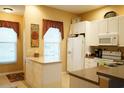 Bright eat-in kitchen featuring white cabinetry, a center island and an abundance of natural light at 311 Kelsey Way # 3, Sun City Center, FL 33573