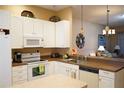 Well-lit kitchen with white appliances and ample counter space, ideal for cooking and entertaining at 311 Kelsey Way # 3, Sun City Center, FL 33573