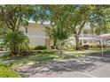 Charming two-story home with a white roof, set amidst lush landscaping and mature trees creating a serene environment at 3702 54Th W Dr # 104, Bradenton, FL 34210