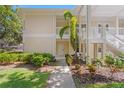 Elegant two-story condo features well-maintained landscaping, a white exterior, and inviting entryway at 3702 54Th W Dr # 104, Bradenton, FL 34210