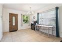 Bright living room featuring tile floors, a chandelier, and a decorative front door at 4412 Bray Rd, Tampa, FL 33634