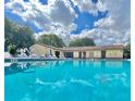 Community pool on a sunny day with lounge chairs and a clubhouse at 501 E Bay Dr # 3504, Largo, FL 33770