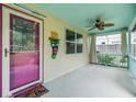 Inviting covered porch with turquoise accents, fan, decorative mask, and a peek at the outdoor garden at 507 4Th Sw Ave, Largo, FL 33770