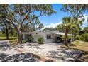 Charming single-story home with mature trees, gravel drive, and covered parking at 5270 Miller Bayou Dr, Port Richey, FL 34668
