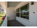 Charming front porch with large windows, a welcome sign, and outdoor seating at 5270 Miller Bayou Dr, Port Richey, FL 34668