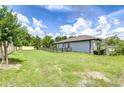 Spacious backyard with lush green grass enclosed by a sleek black fence, providing a secure area and ample space at 6119 Bradford Woods Dr, Zephyrhills, FL 33542