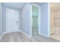 Inviting entryway features wood-look floors, white doors and trim, and a view into the adjacent bathroom and living spaces at 6119 Bradford Woods Dr, Zephyrhills, FL 33542
