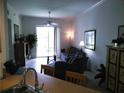 Inviting living room with neutral colors, tile floors, and sliding glass doors offering scenic views at 6714 Dali Ave # 102, Land O Lakes, FL 34637