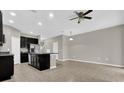 Open kitchen and living area with black cabinets and an island under a ceiling fan at 6924 Towne Lake Rd, Riverview, FL 33578