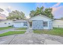 Single-story home featuring stone accents and a well-manicured lawn at 7033 Wentworth Way, New Port Richey, FL 34655