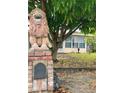 Charming home featuring a lion statue at the mailbox and mature trees in the front yard at 72 Lake Shore Dr, Palm Harbor, FL 34684