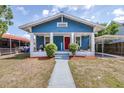 Charming blue craftsman-style home with a red door, white trim, and front porch at 910 E Chelsea St, Tampa, FL 33603