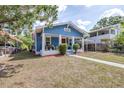 Charming blue craftsman-style home with a red door, white trim, and front porch at 910 E Chelsea St, Tampa, FL 33603