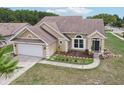 Single-story home with a manicured lawn, flower beds and an attached two-car garage, beautifully designed with modern fixtures at 9322 Via Segovia, New Port Richey, FL 34655