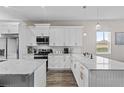 Modern kitchen featuring white cabinets, stainless steel appliances, and a large center island with marble countertops at 1006 E 23Rd Ave, Tampa, FL 33605
