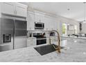 Bright kitchen showcasing white cabinets, stainless steel appliances, marble countertops and modern fixtures at 1006 E 23Rd Ave, Tampa, FL 33605
