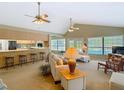 Bright and airy living room featuring a ceiling fan, neutral colors and seamless connection to the kitchen at 10930 Marjory Ave, Tampa, FL 33612
