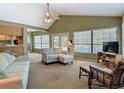 Spacious living room with vaulted ceilings, neutral decor, large windows and access to the outdoor pool area at 10930 Marjory Ave, Tampa, FL 33612
