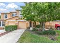 Inviting townhome showcases a well-maintained lawn, lovely tree, and an arched entryway at 11615 Mango Ridge Blvd # 39, Seffner, FL 33584