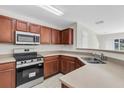Well-lit kitchen featuring stainless steel appliances, wood cabinets, and light countertops at 11615 Mango Ridge Blvd # 39, Seffner, FL 33584