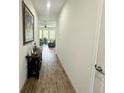 Hallway showcasing wood-style tile flooring, neutral walls and view into the living area at 12032 Grand Kempston Dr, Gibsonton, FL 33534
