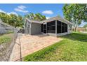 Fenced backyard with a screened-in patio and adjacent brick pavers for outdoor enjoyment at 12401 Yorktown Ln, Bayonet Point, FL 34667