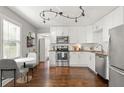 Bright kitchen with white cabinetry, stainless steel appliances, hardwood floors, and ample counter space at 1302 E Flora St, Tampa, FL 33604
