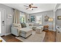 Inviting living room featuring a large sectional sofa, hardwood floors, and natural light from the windows at 1302 E Flora St, Tampa, FL 33604