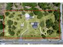 Aerial view of property lines, including home, outbuildings, and lush landscaping at 13341 Hexam Rd, Weeki Wachee, FL 34613
