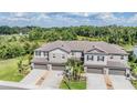 An aerial view showcasing a block of townhomes nestled against a lush green space at 1396 White Fox Run, Lutz, FL 33549
