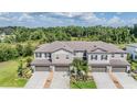 An aerial view showcasing a block of townhomes nestled against a lush green space at 1396 White Fox Run, Lutz, FL 33549