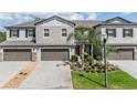 Charming two-story townhome featuring attached garages and beautifully landscaped front yard at 1396 White Fox Run, Lutz, FL 33549