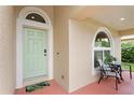 Inviting front porch with a light green door, a sitting area, and an arched window for a cozy welcome at 14612 Corkwood Dr, Tampa, FL 33626