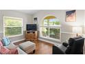 Bright living room with large windows, wood floors, and a comfortable seating arrangement at 14612 Corkwood Dr, Tampa, FL 33626