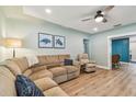 Cozy living room with plush sectional sofa, wood floors, and light green walls at 1529 Essex N Dr, St Petersburg, FL 33710