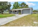 Single-story home with a concrete driveway and a quaint front entrance at 1569 Larkin Rd, Spring Hill, FL 34608