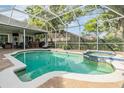 Inviting screened-in pool and spa area, complete with an outdoor bar and a serene backyard view at 2216 Eagle Bluff Dr, Valrico, FL 33596