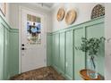 Inviting entryway with decorative wall trim, modern decor, and a glass-paneled front door at 2401 Morninglight Dr, Lutz, FL 33558