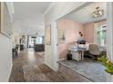 Open floor plan showcasing a home office with a pink accent wall and stylish furnishings at 2401 Morninglight Dr, Lutz, FL 33558