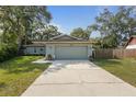 Single-story home featuring an attached two-car garage and concrete driveway at 3205 Coventry N, Safety Harbor, FL 34695