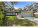 Beautiful one-story home with a well-maintained lawn, landscaping, and attached garage at 3205 Coventry N, Safety Harbor, FL 34695