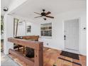Inviting front porch featuring terra cotta tile flooring, rustic wooden bar, and ceiling fan at 3310 W Ballast Point Blvd, Tampa, FL 33611